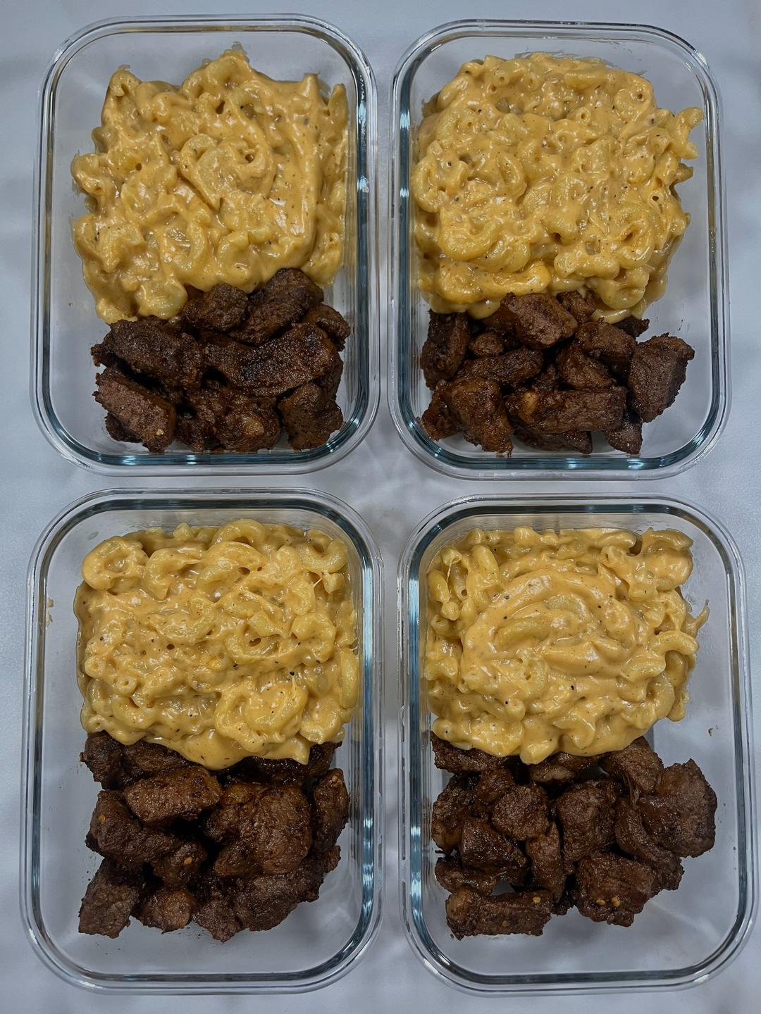 Four prepared servings of Garlic Steak Bites with Mac & Cheese