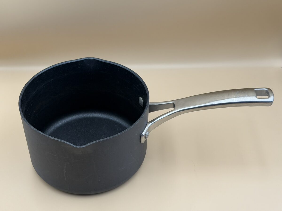 A black everyday saucepan with a metal handle