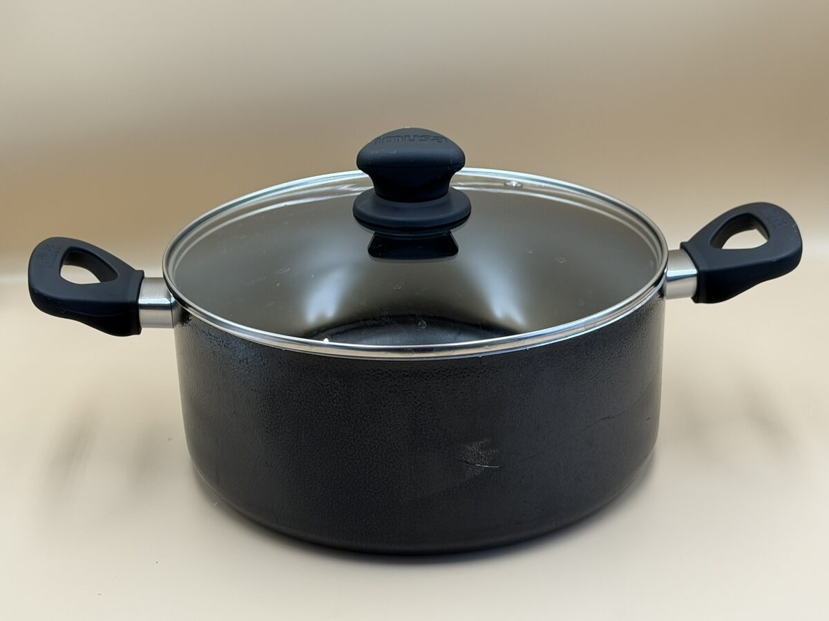 A black everyday stock pot with two metal handles