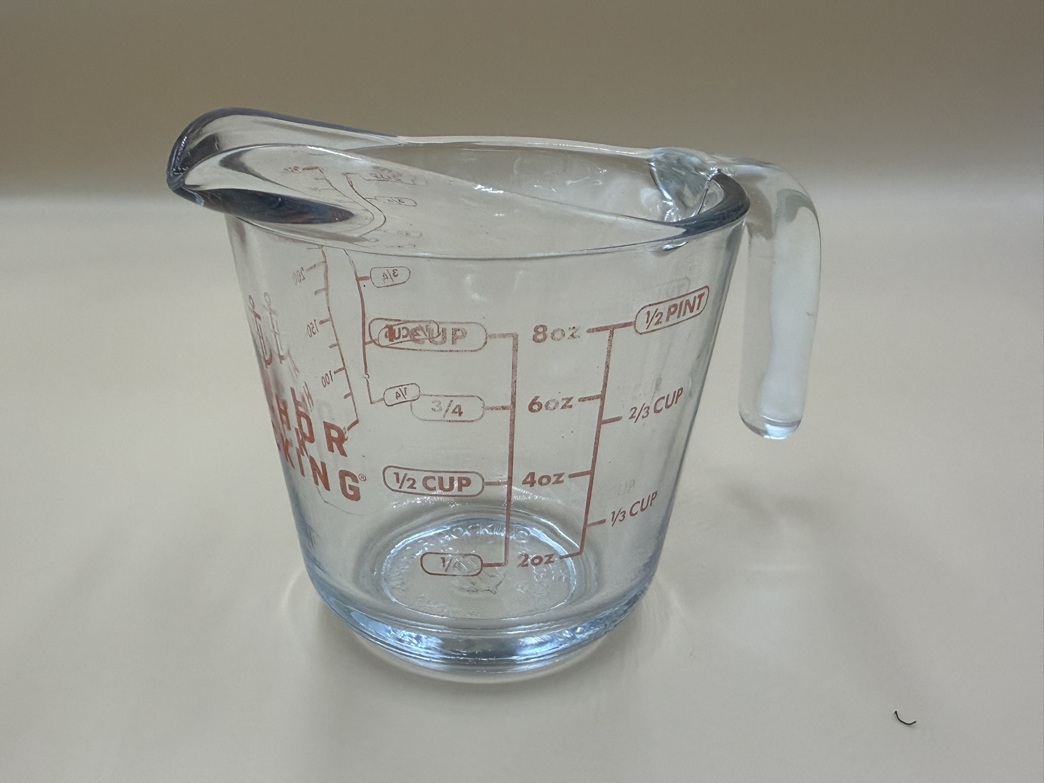 A clear glass liquid measuring cup