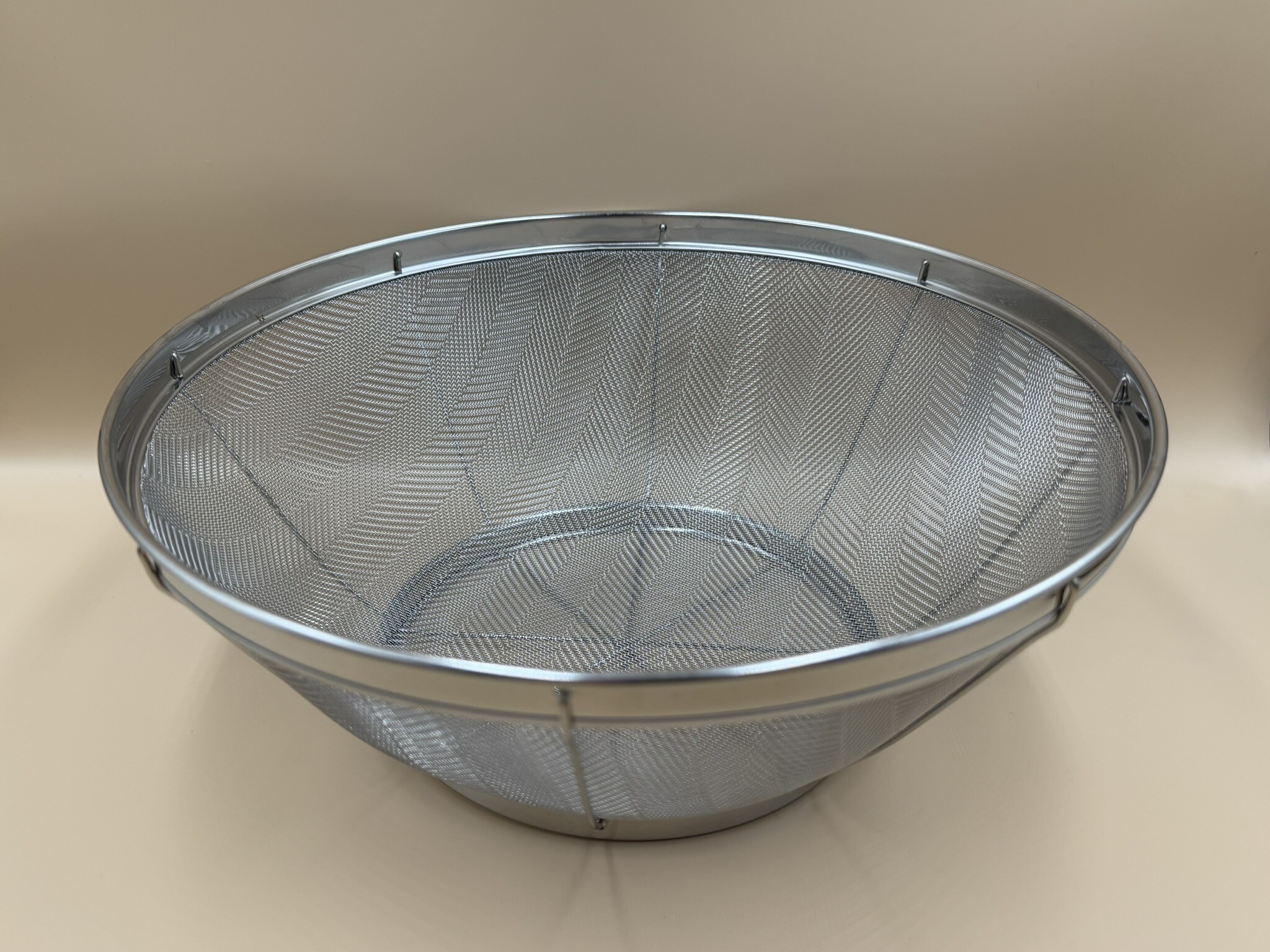 A round metal mesh colander